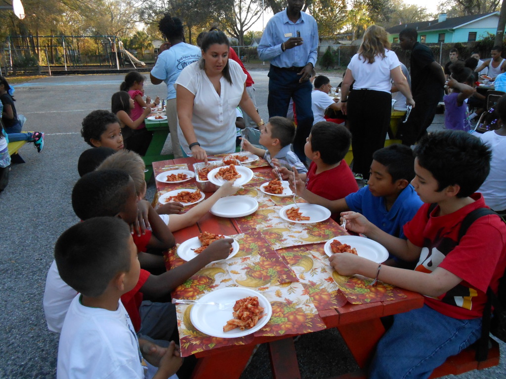 A group of children sitting at a table with plates.