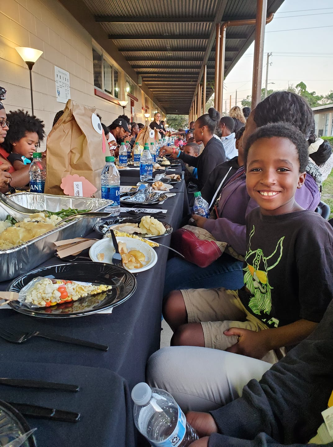 A group of people sitting around a table with food.