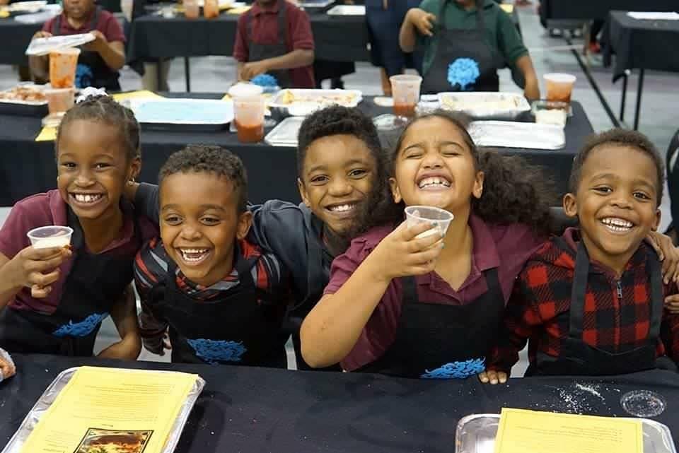 A group of kids sitting at a table with food.