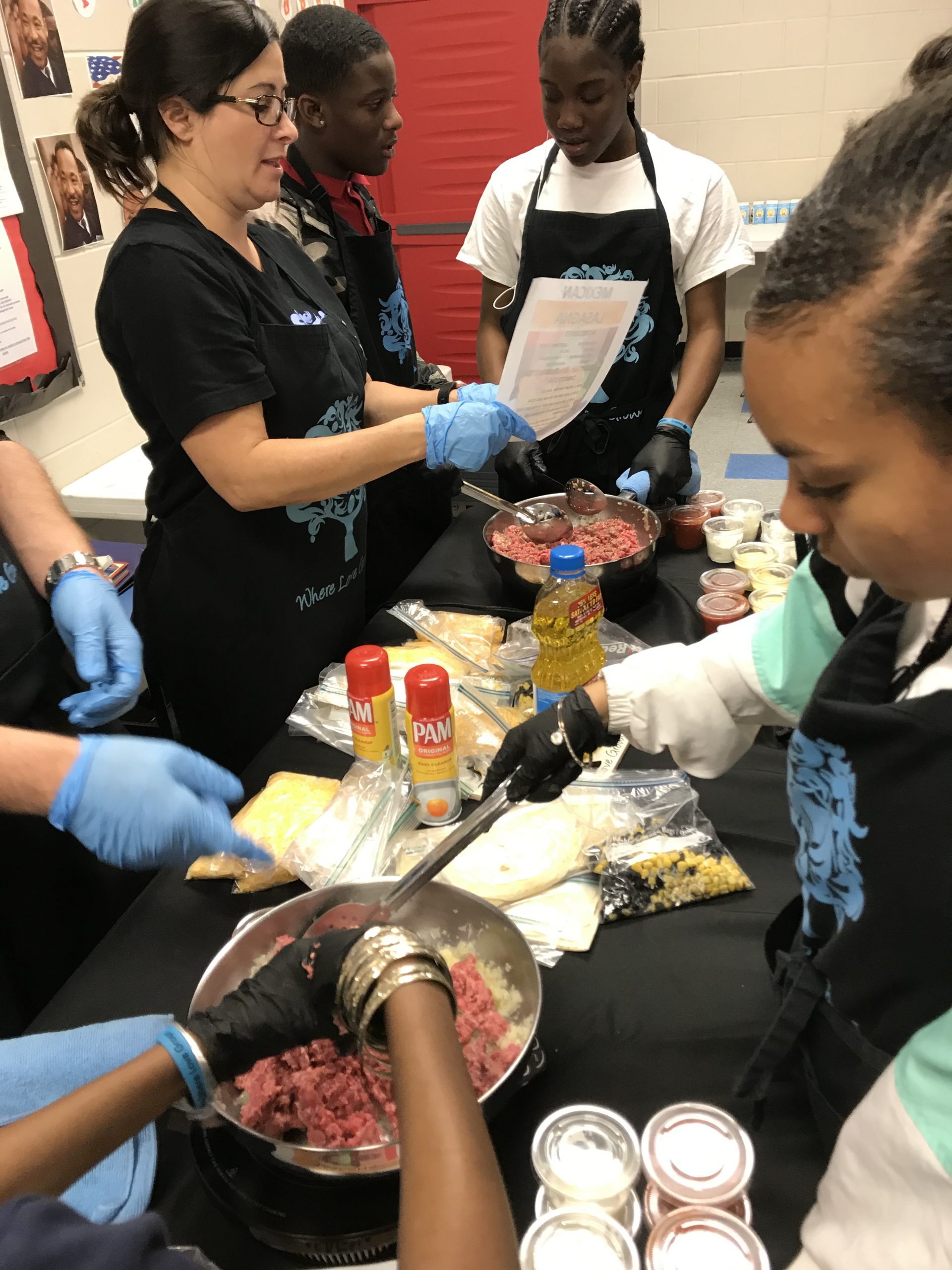 A group of people in blue gloves preparing food.