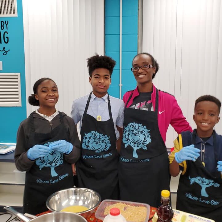 Four children in aprons posing for a picture.