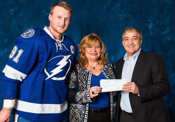 A man and woman holding a check for $ 1 0, 0 0 0.